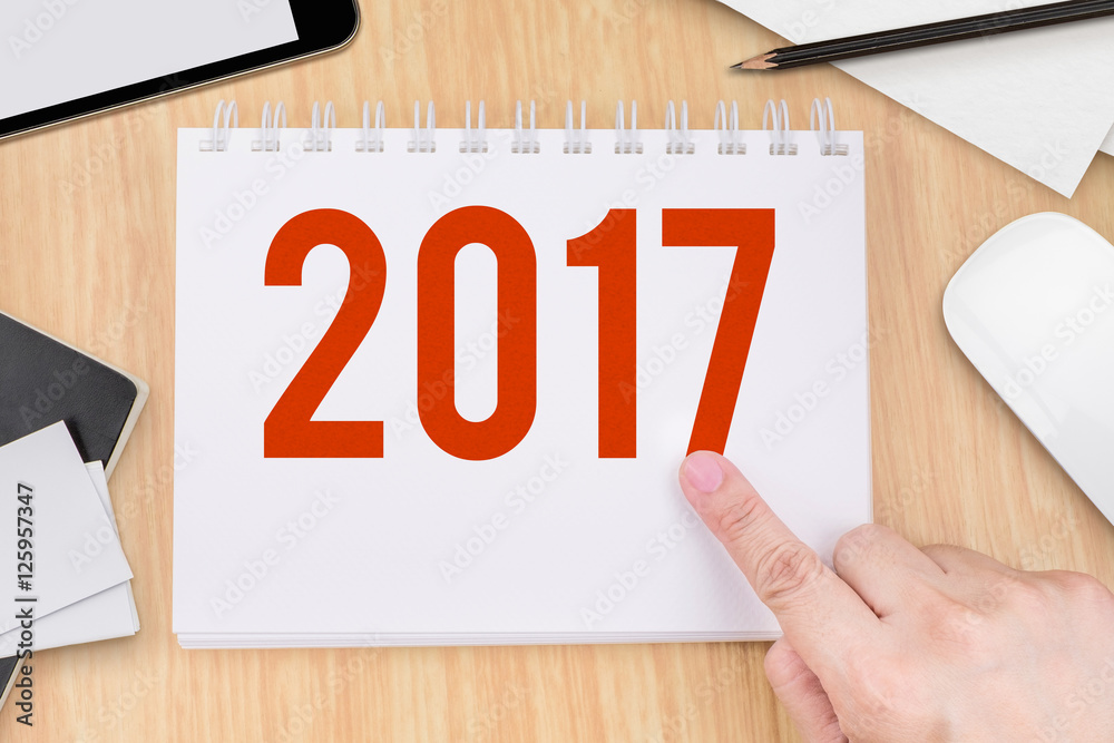 Fototapete hand point at 2017 year number on notebook and technology device