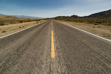 Asphalt road stretching to the horizon in Death Valley National Park, CA, USA