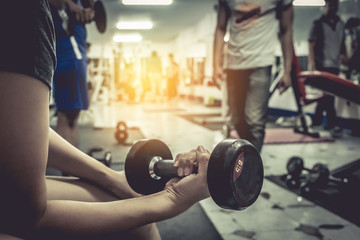 Healthy woman with dumbbell in gym. vintage.
