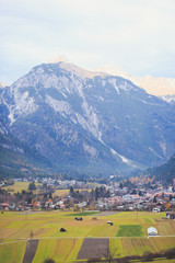 Fototapeta na wymiar Picture of classic beautiful vibrant Austrian landscape mountain road view with Alps mountains, bridge, cows, meadows and village, Austria