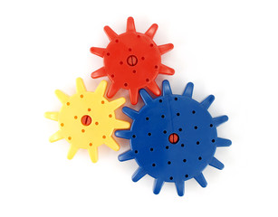 connecting colorful plastic gear wheels (blue red and yellow color) isolated on white background,...
