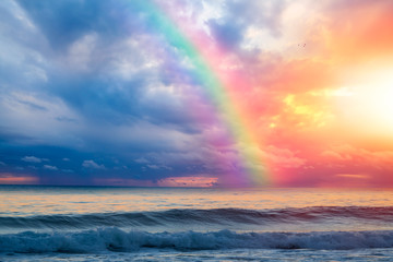Wunderschöne Landschaft mit türkisfarbenem Meer, Regenbogen über dem Meer bei Sonnenuntergang