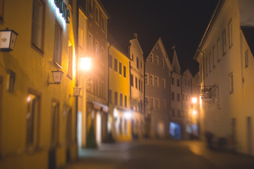 Beautiful vibrant multicolored downtown picture of street in Fussen, Bayern, Bavaria, Germany, with tourists and people walking near shop-windows and restaurants, houses in bavarian style