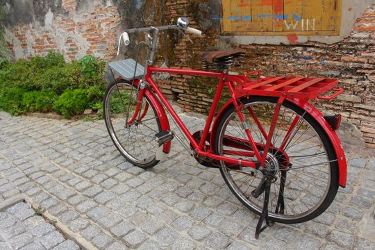 Vintage Red bicycle near the window of old brick wall home background