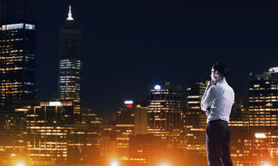 Businessman viewing night glowing city