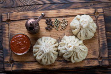 Above view of khinkali or georgian meat dumplings with satsebeli