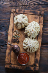 Georgian khinkali on a rustic wooden serving tray, above view