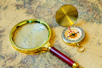The compass and magnifying glass gold color on the old map