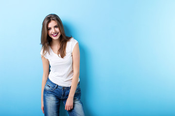 Modern woman smiling on blue.