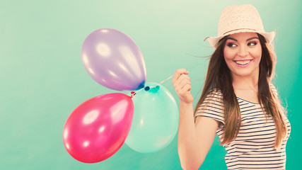 Happy girl playing with colorful balloons.