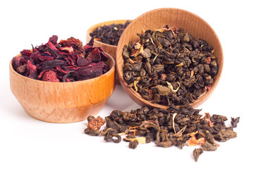 Dry tea in wooden plates, on white background. Leaves of red, green and black tea. Macro photo.