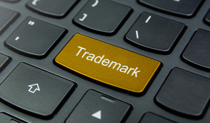 Business Concept: Close-up the Trademark button on the keyboard and have Gold, Yellow color button isolate black keyboard