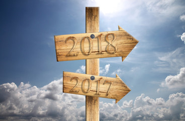 Wood sign of 2017 and 2018 in in right on blue sky background.