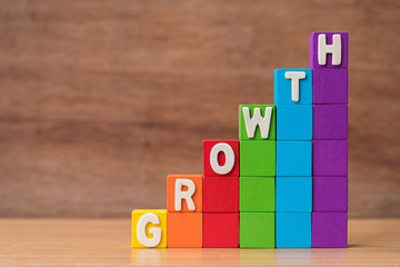 text GROWTH on stack of colorful wood cube building blocks