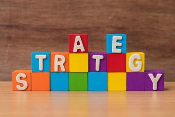 text STRATEGY on stack of colorful wood cube building blocks