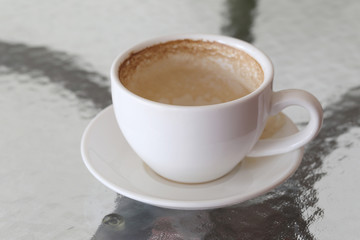 White coffee mug with coffee stains on table.
