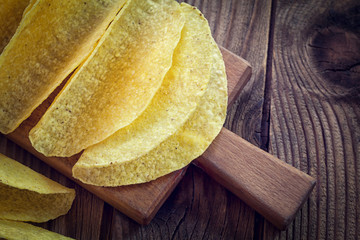 Tacos - Mexican yellow corn tortilla, empty shell on wooden cutting board