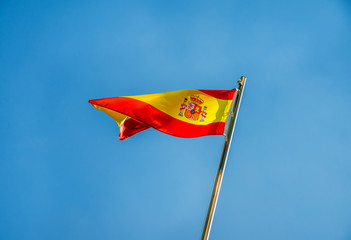     Spanish flag flying on a metal flag pole 