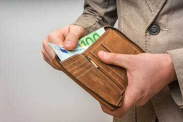Leather wallet with euro money in male hands