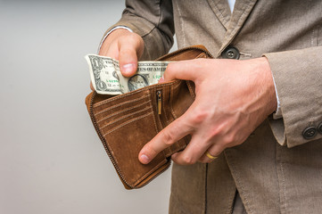 Man holding wallet with only one dollar inside