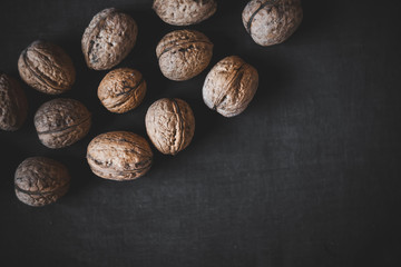 Many walnuts on a black background. Place for text. Autumn.