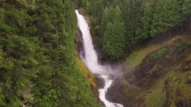 Slow Floating Nature Aerial at Big Misty Waterfall in Bright Green Forest