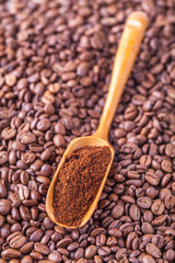 wooden spoon with ground coffee beans background
