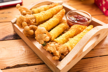 Golden needle mushroom with wonton fried on wooden dish