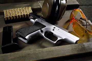 Fototapeta Pistolet CZ Shadow. Pistolet Cz, naboje i słuchawki ochraniające uszy, sprzęt strzelecki obraz