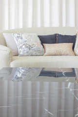 Luxury style pillows on beige sofa with marble top table in foreground