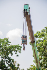 Old and rusty chain pulley, at construction site with crane hook
