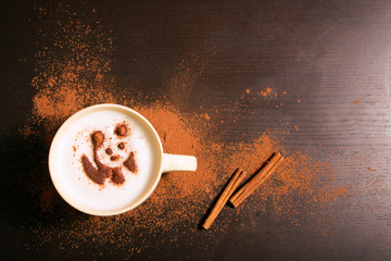 Cup of coffee with panda pattern of cinnamon