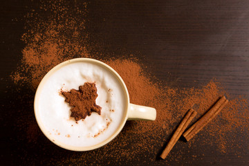 Cup of coffee with maple leaf pattern of cinnamon