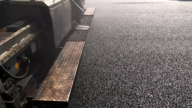 Surface of black asphalt. Back part of road paver. Building roads from best materials. New work plan.