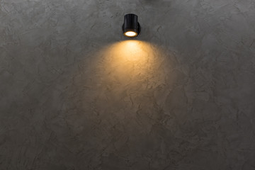 Black wall lamp on grey mortar wall background