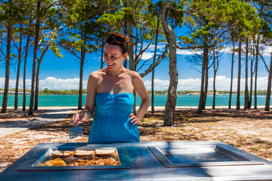 Young Happy Woman Cooking Barbeque On The Beach In Australia