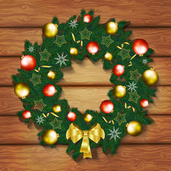 Christmas wreath with balls and gold bow on wooden background. V
