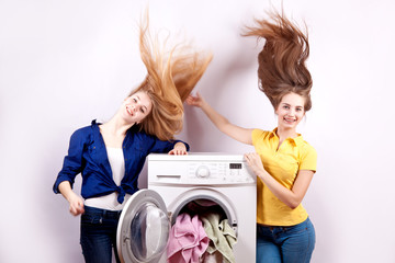 Two girls and a washing machine on  white background