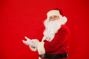 Santa Claus pointing in blank a place, red background
