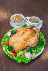 Roasted turkey stuffing garnished with Vegetables served with gravy sauce on a rustic style table. Christmas Dinner