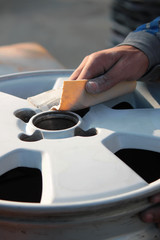 uomo carrozziere a lavoro su ruota auto