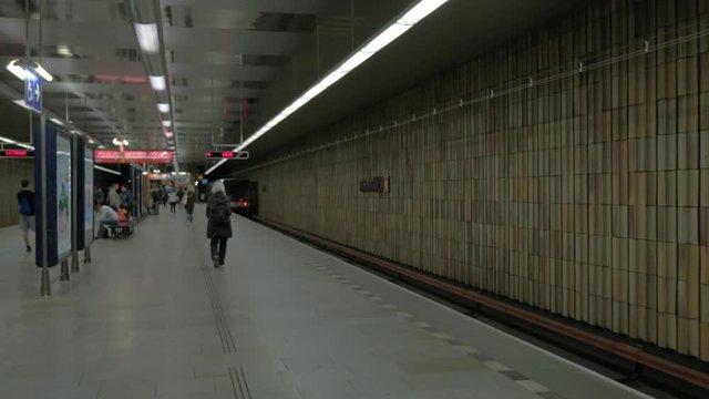 View of moving away subway train on the station. Lighting electronic screen and subway maps on the sides, Prague, Czech Republic