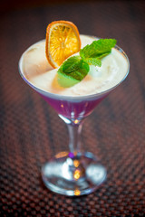 сливочный ежевичный мусс с долькой апельсина на темном фоне