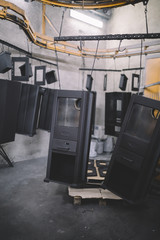 Metallurgy industry interiors. Details from factory for production of heavy pellet stoves and boilers. Sector for painting. Extremely dark conditions and visible noise.