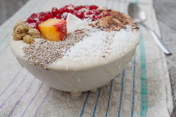 vegan banana smoothie with pomegranate, mulberry, coconut, Chia, carob. Raw fruit energy food. Detof and healthy breakfast bowl. 