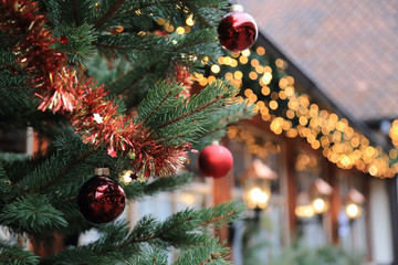 Christmas street decorations - red ball, fir and bokeh lights
