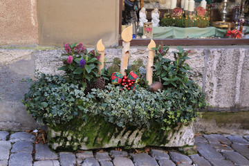 Christmas street decorations with wooden candles, cones and plants
