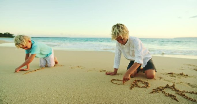 Young kids playing on the beach drawing in the sand