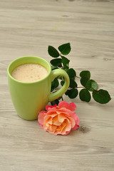 A mug of coffee with an orange rose