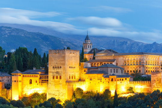 Palace and fortress complex Alhambra with Comares Tower, Palacios Nazaries and Palace of Charles V during evening blue hour in Granada, Andalusia, Spain